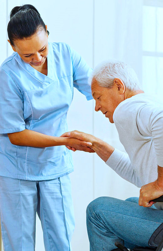 caregiver helping senior man to get up on his wheelchair