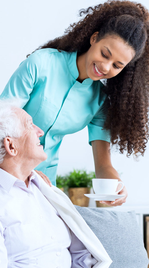 caregiver and senior man are smiling