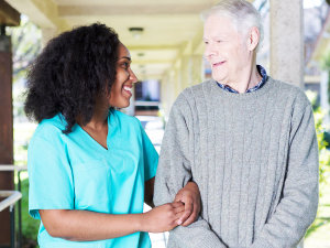 caregiver and senior man are smiling