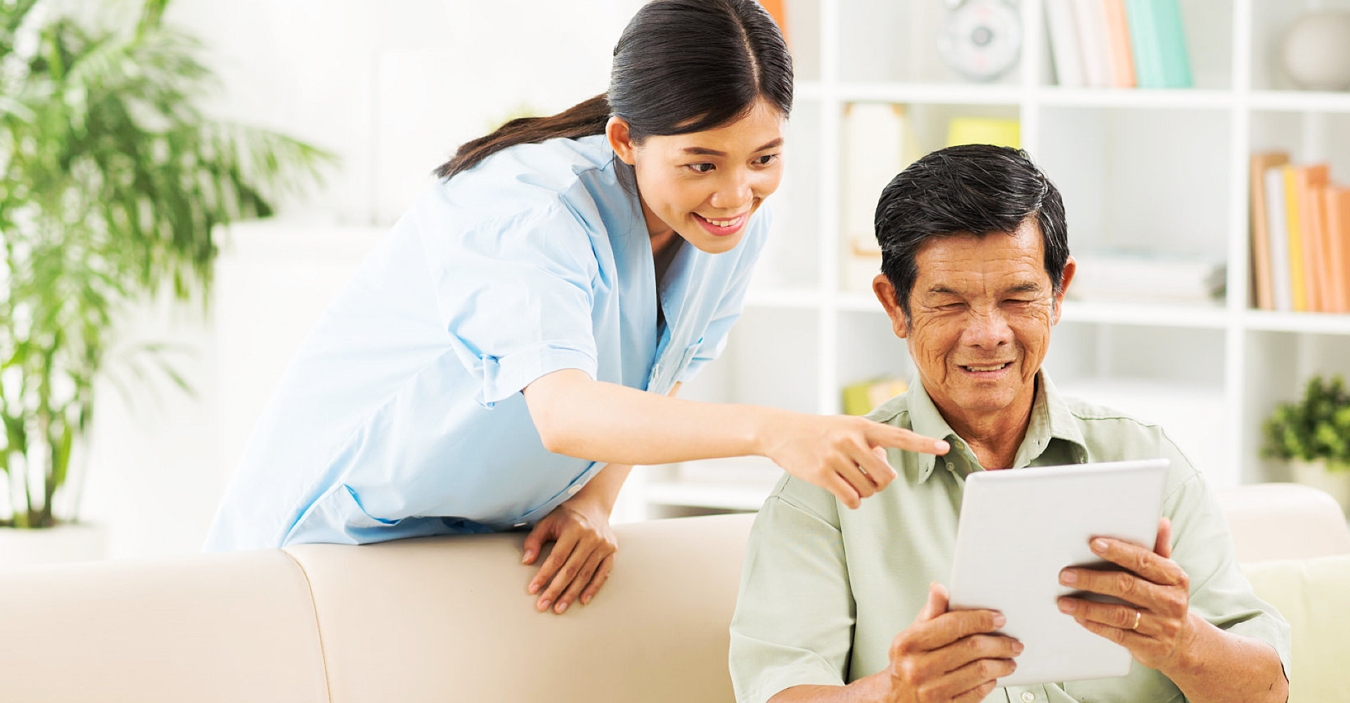 caregiver and senior man are smiling